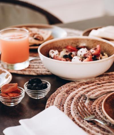 Colazione con frutta, pane, succo e yogurt in un'atmosfera accogliente.