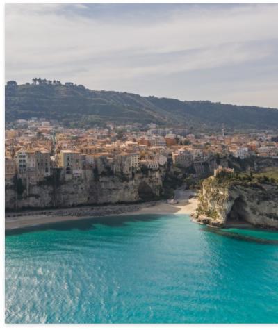Vista panoramica di Tropea con scogliere e mare turchese.