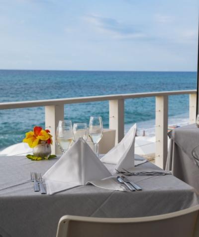 Tavolo apparecchiato con vista mare, bicchieri di vino e champagne Moët & Chandon.