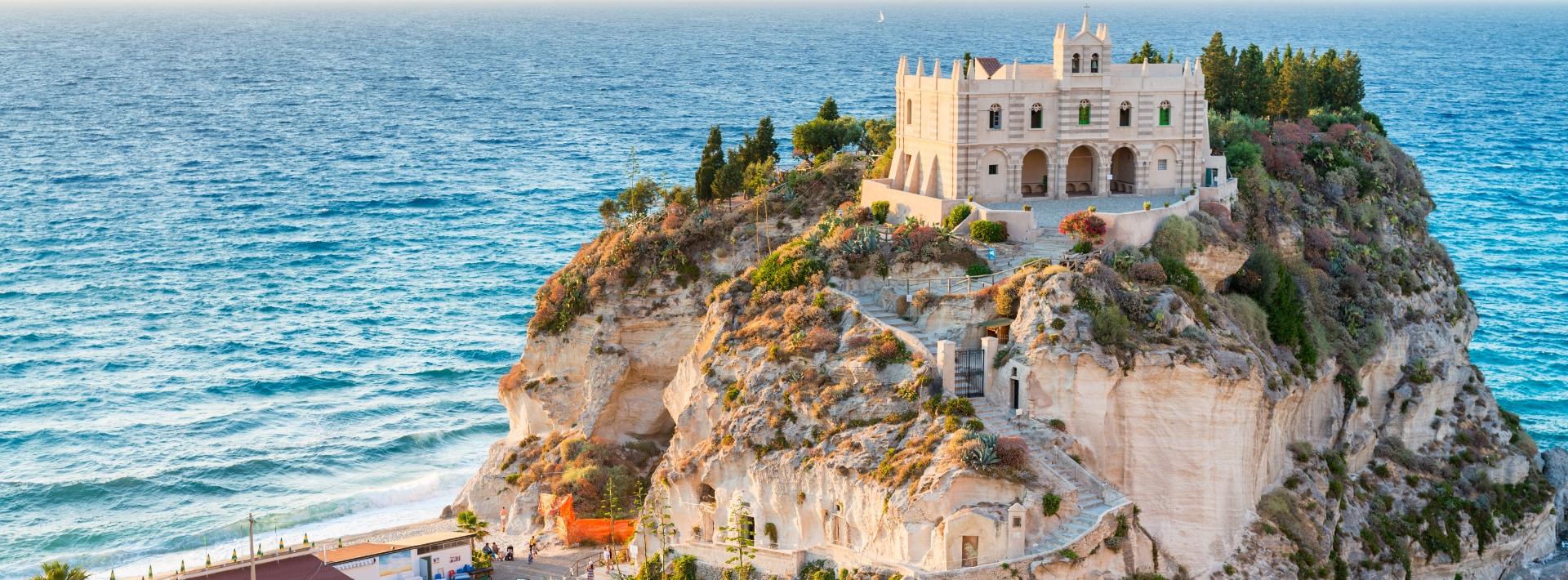 Santuario su scogliera con vista mare, circondato da vegetazione mediterranea e sentieri.
